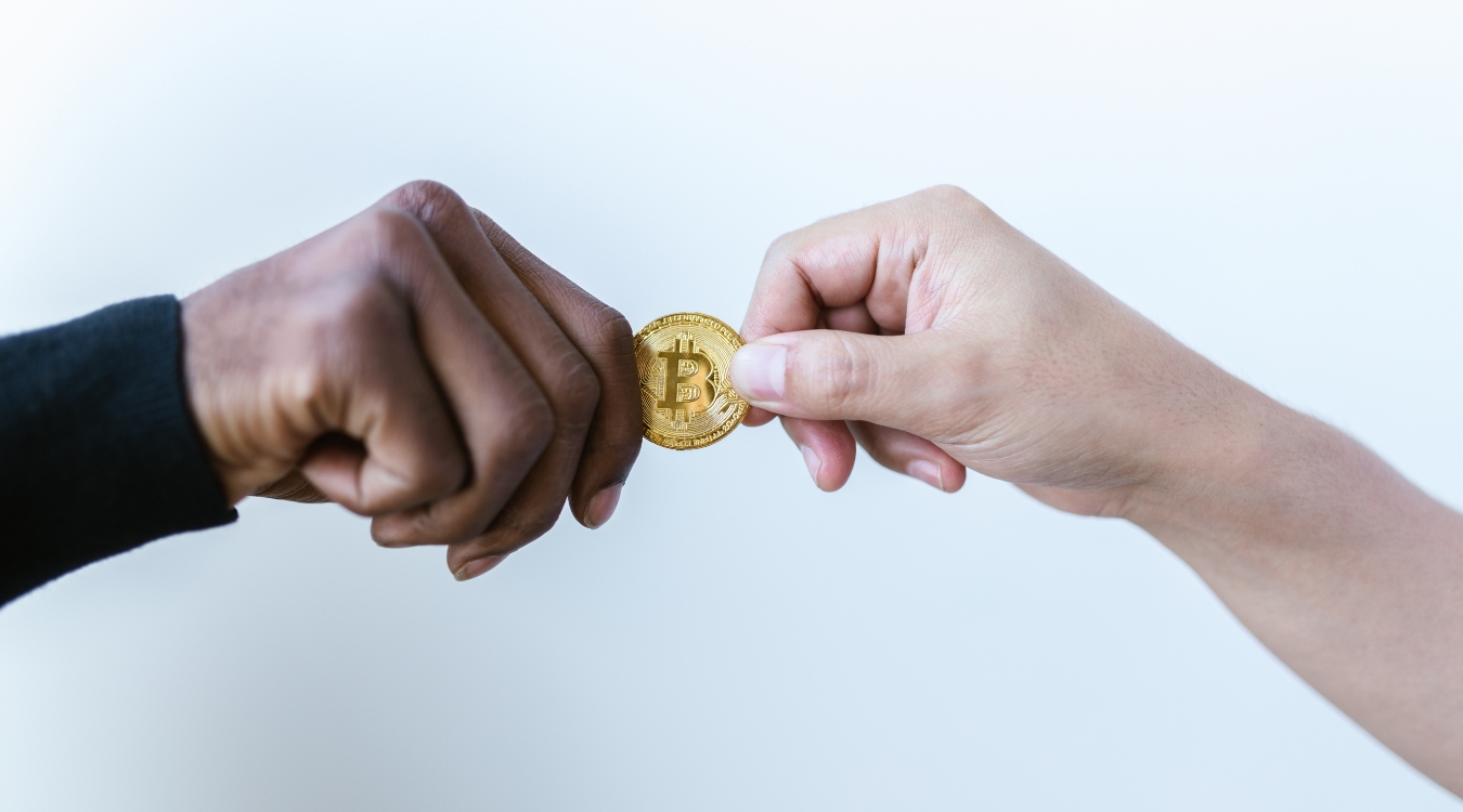 Filipino freelancer receiving physical bitcoin from international client showing hands exchanging cryptocurrency payment