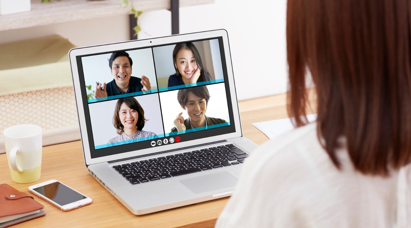 Middle-aged female foreign client conducting video call orientation session with four Filipina freelancers on laptop during remote onboarding process