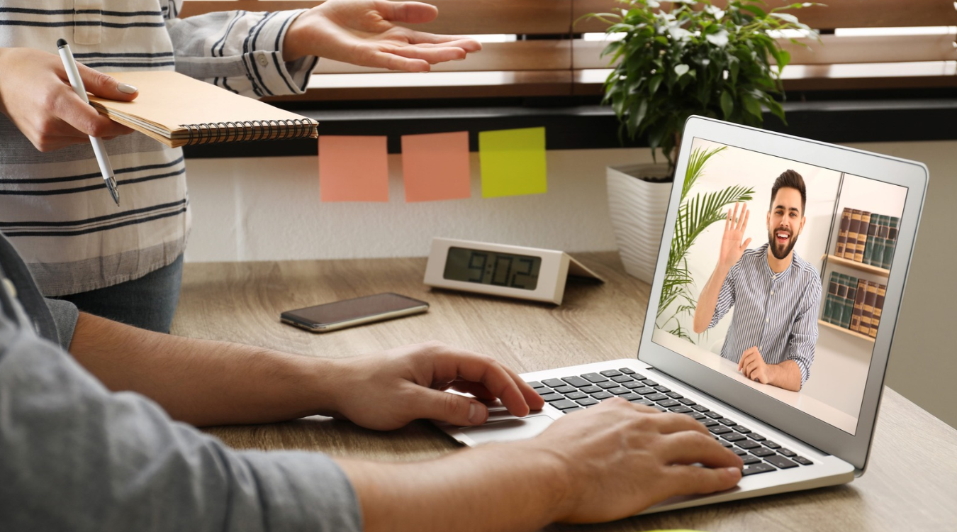 Two Filipino freelancers receiving feedback from foreign client on laptop screen during video call without showing their faces